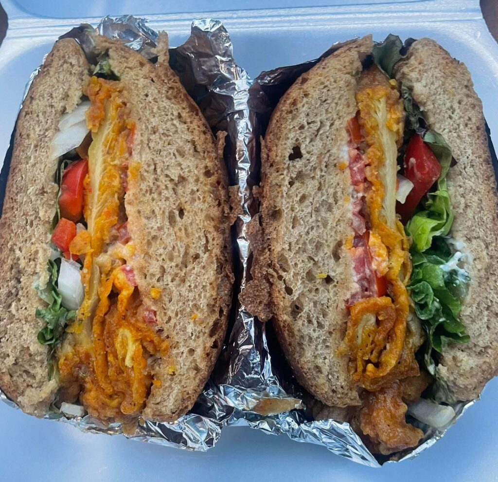 Close up shot of Local Harvest Café's Oyster Mushroom Veggie Burger showing the layers of ingredients within the burger.
